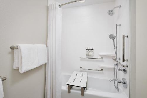 baño blanco con ducha y lavamanos en Holiday Inn Express Hotel & Suites Port St. Lucie West, an IHG Hotel, en Port Saint Lucie