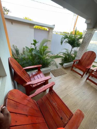 a patio with two wooden chairs and a table at Villa confortable para 7 personas in Pedernales