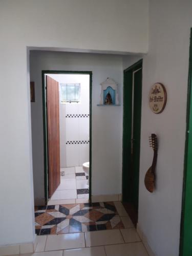 a hallway with a bathroom with a guitar on the wall at Estalagem das Estrelas in Cristalina