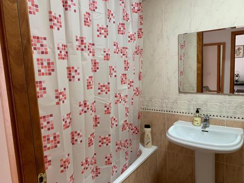baño con lavabo y cortina de ducha en Apartamentos OlaMar, en Lloret de Mar