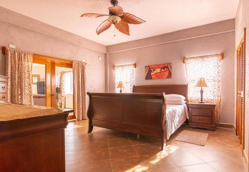 a bedroom with a bed and a ceiling fan at Lighthouse Beach Villas in San Pedro