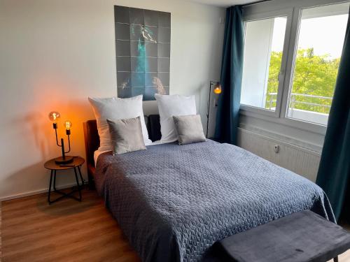 sypialnia z łóżkiem z poduszkami i oknem w obiekcie River Main I Taunus View I Workplace I Kitchen w mieście Offenbach