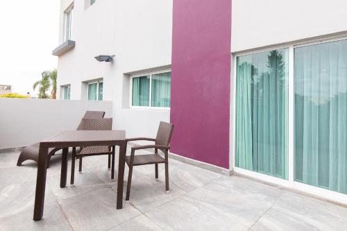 a table and chairs on a balcony with a purple wall at HS HOTSSON Smart León Centro Max in León