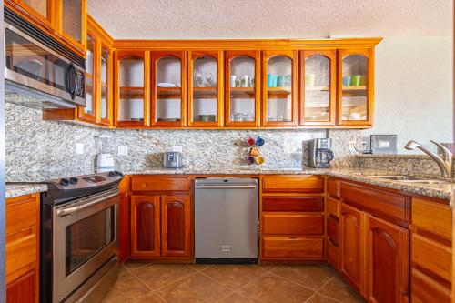 a kitchen with wooden cabinets and a dishwasher at Lighthouse Beach Villas in San Pedro