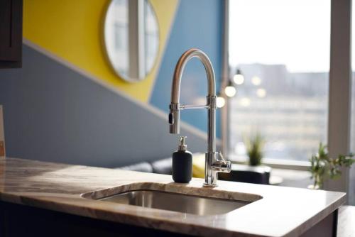 a kitchen sink with a soap dispenser on it at HostWise Stays - The Washington at Chatham - Free Parking, Private Gym, City Views! in Pittsburgh