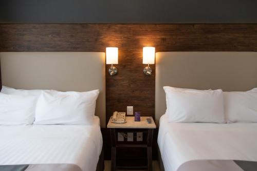 a hotel room with two beds and a phone on a table at HS HOTSSON Smart León Centro Max in León