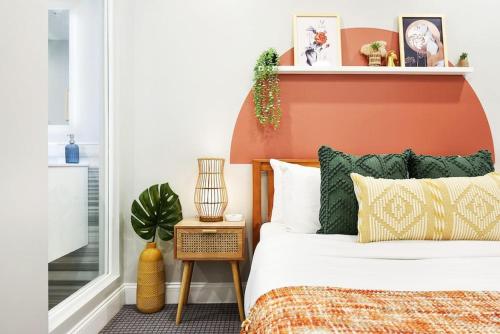 Schlafzimmer mit einem Bett mit einem orangefarbenen Kopfteil in der Unterkunft HostWise Stays - The Washington at Chatham - Free Parking, Private Gym, More! in Pittsburgh