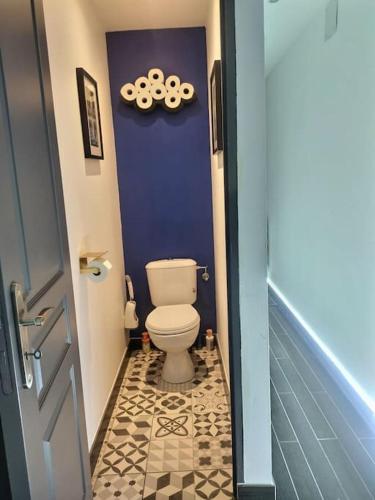 a bathroom with a toilet and a purple wall at Maison spacieuse 240m² - 7chambres - 16pers' in Woippy
