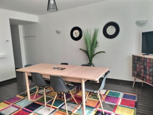 a dining room with a table and chairs on a rug at Maison spacieuse 240m² - 7chambres - 16pers' in Woippy