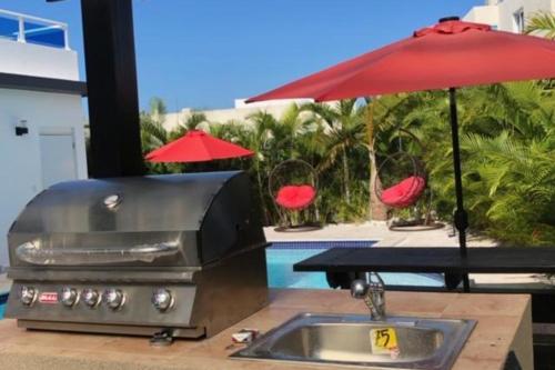 a grill and an umbrella on a table at Sosua 3 Master suites Private Luxury Villa Private pool BBQ more in Laguna del Higüero