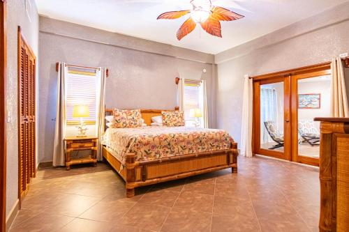 a bedroom with a bed and a ceiling fan at Lighthouse Beach Villas in San Pedro