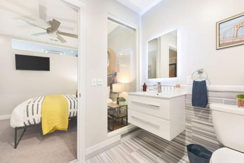 a white bathroom with a sink and a mirror at HostWise Stays - The Washington at Chatham - Free Parking, Fitness Center in Pittsburgh