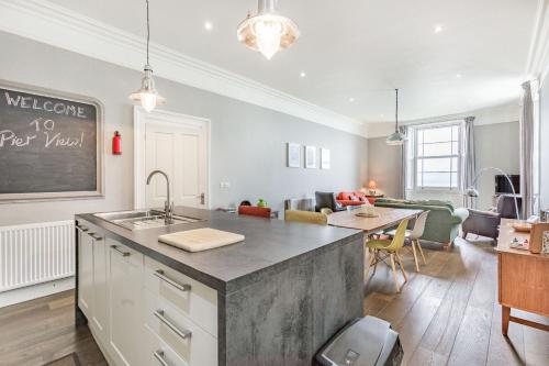 a kitchen and living room with a sink and a table at Pier View in Weston-super-Mare