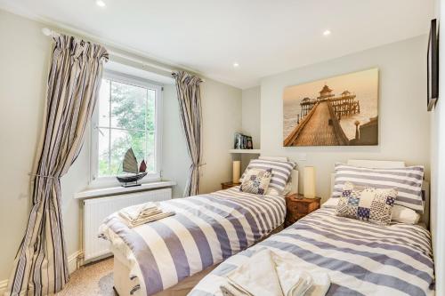 two beds in a room with a window at Pier View in Weston-super-Mare