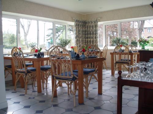 a dining room with a table and chairs and windows at Sea Dew B&B in Tullamore