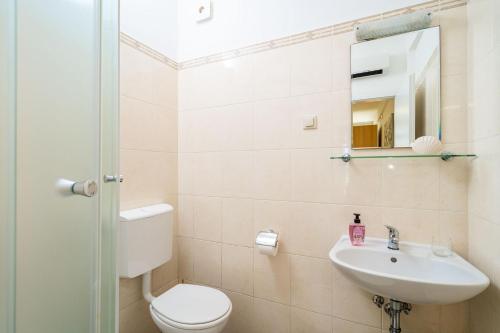 a bathroom with a toilet and a sink and a mirror at Green Paradise in Mlini
