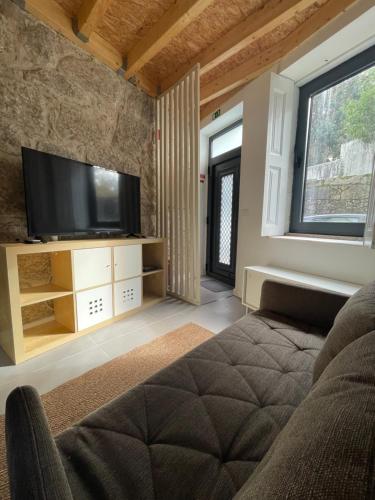 a living room with a tv and a couch at Bonjóia Porto Guest House in Porto