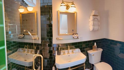 a bathroom with two sinks and a toilet and a mirror at Nicholson House at Beaujolais in Mendocino