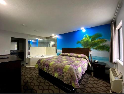 a hotel room with a bed and a blue wall at DELUXE INN in Erie