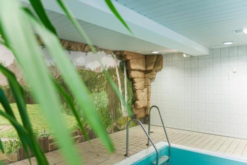 Hotel Gondelfahrt في كورورت جونسدورف: غرفة مع حمام سباحة بجدار حجري