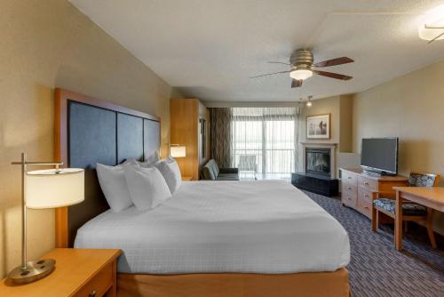 a hotel room with a large bed and a television at Best Western Plus Ocean View Resort in Seaside