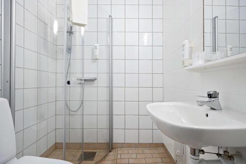 uma casa de banho branca com um lavatório e um chuveiro em Sure Hotel by Best Western Lagan em Lagan