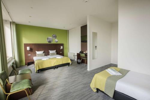 a hotel room with two beds and a desk at Flonk Hotel Groningen Centre, BW Signature Collection in Groningen