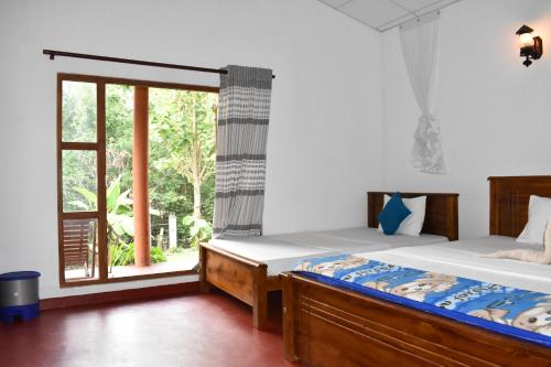 een slaapkamer met een bed en een raam bij Nil Bawana Nature Resort in Udawalawe