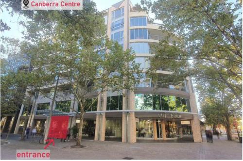 a large building with a tree in front of it at Private room with ensuite in the CBD in Canberra