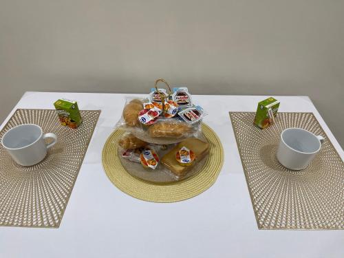una mesa con un plato de repostería y dos tazas en La Dimora Dei Sogni en Nápoles
