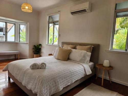 1 dormitorio con 1 cama con 2 toallas en Classic Brisbane Queenslander with Pool & Yard, en Brisbane