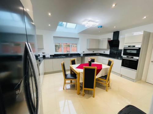 a kitchen with a table with chairs and a red table cloth at 4-Bedroom Cottage in Healing, Grimsby in Grimsby