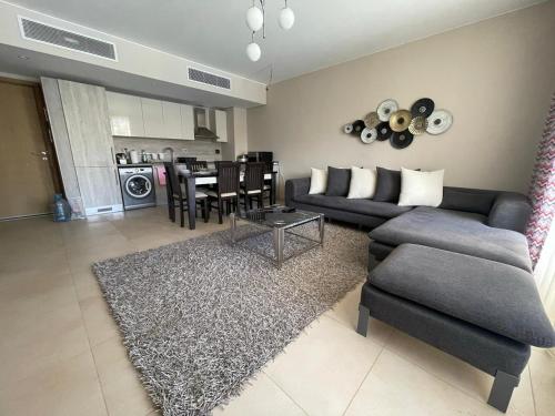 a living room with a couch and a table at Lovely 2-bedroom apartment with pool view in Hurghada