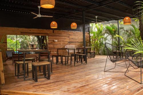 a restaurant with wooden tables and chairs on a deck at Refugio Surf Lodge in Tamarindo
