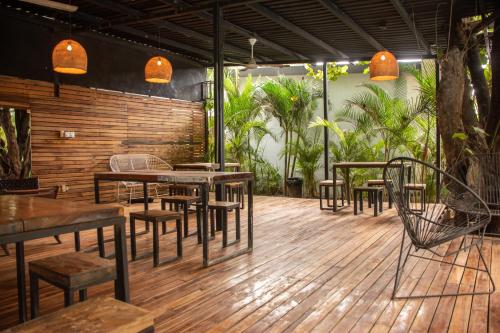a restaurant with tables and chairs on a wooden deck at Refugio Surf Lodge in Tamarindo