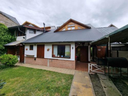a house with a metal roof and a yard at Cabañas Del Lacar in San Martín de los Andes