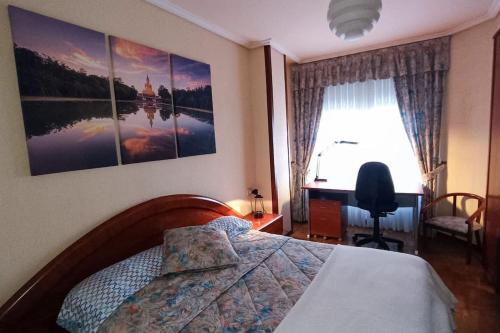a bedroom with a bed and a desk and a window at apartamento centro in Vitoria-Gasteiz