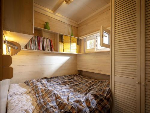 1 dormitorio con 1 cama en una habitación con paredes de madera en Tranquil bungalow in Lille with garden, en Lille