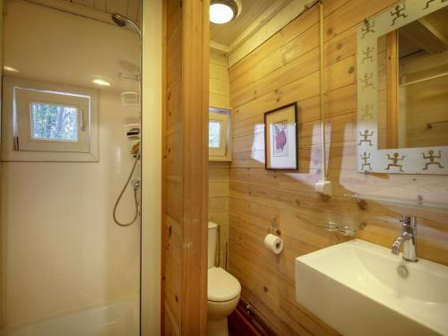 La salle de bains est pourvue de murs en bois, d'un lavabo et de toilettes. dans l'établissement Tranquil bungalow in Lille with garden, à Lille