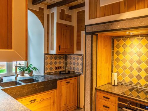 a kitchen with wooden cabinets and a sink at Holiday home Aywaille in Aywaille