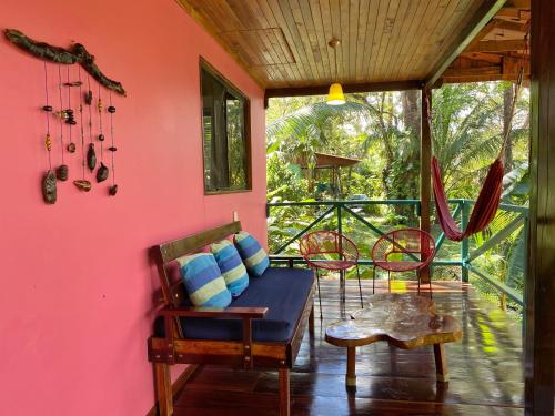 Habitación con sofá y sillas en el porche. en Casa Colores, en Montezuma