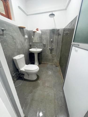 a bathroom with a toilet and a sink at Komox Gedara in Galle