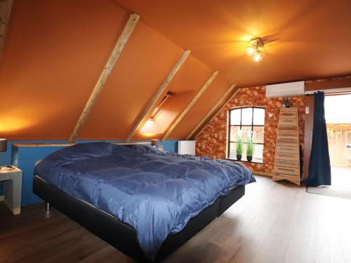 ein Schlafzimmer mit einem blauen Bett in einem Zimmer in der Unterkunft Spend the night in an old flour factory in Haulerwijk