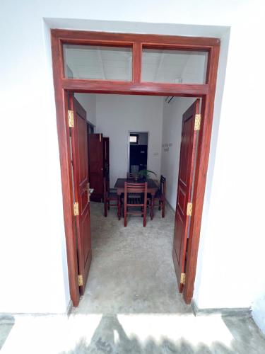 an open door into a dining room with a table at Komox Gedara in Galle