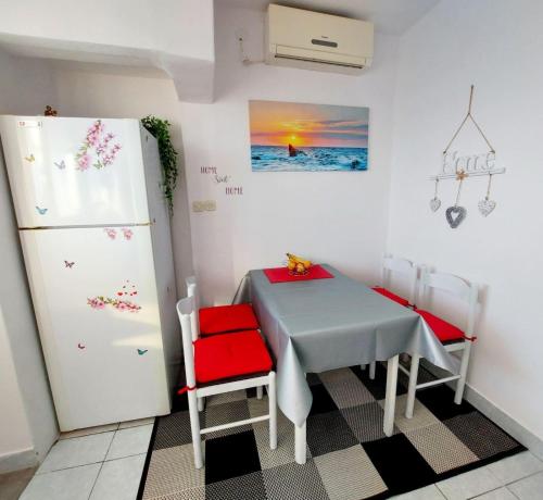 een kleine keuken met een tafel en een koelkast bij Apartments by the sea Sveti Petar, Biograd - 6167 in Sveti Filip i Jakov