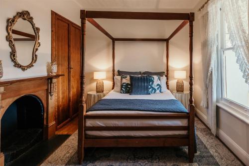 - une chambre avec un lit à baldaquin et une cheminée dans l'établissement Stanley Hotel & Apartments, à Stanley