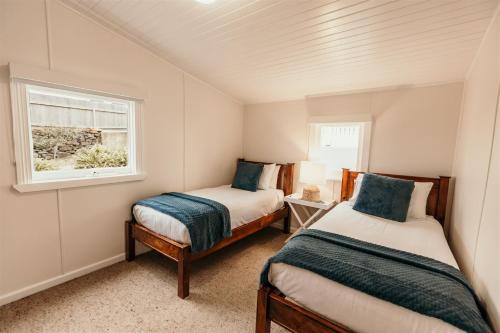 a small bedroom with two beds and a window at Stanley Hotel & Apartments in Stanley