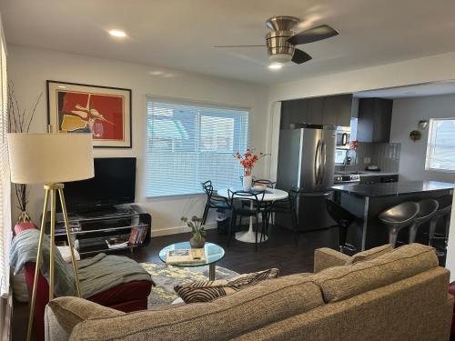 a living room with a couch and a kitchen at Modern Ranch near Knapp Center, Downtown in Des Moines