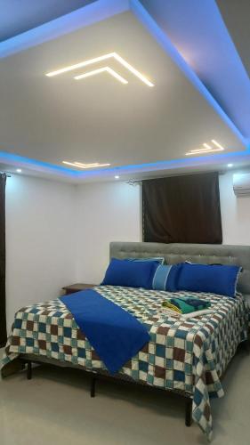 a bedroom with a bed with a blue ceiling at SANTIAGO CITY in Santiago de los Caballeros