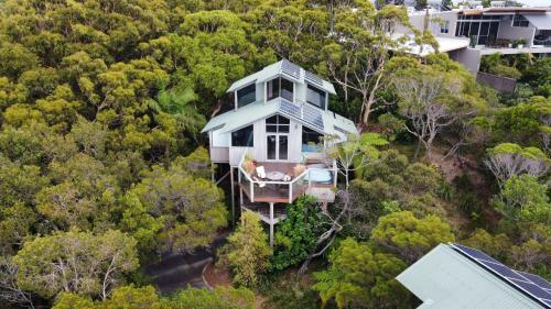 an aerial view of a house on top of a hill at The Oasis Apartments and Treetop Houses in Byron Bay